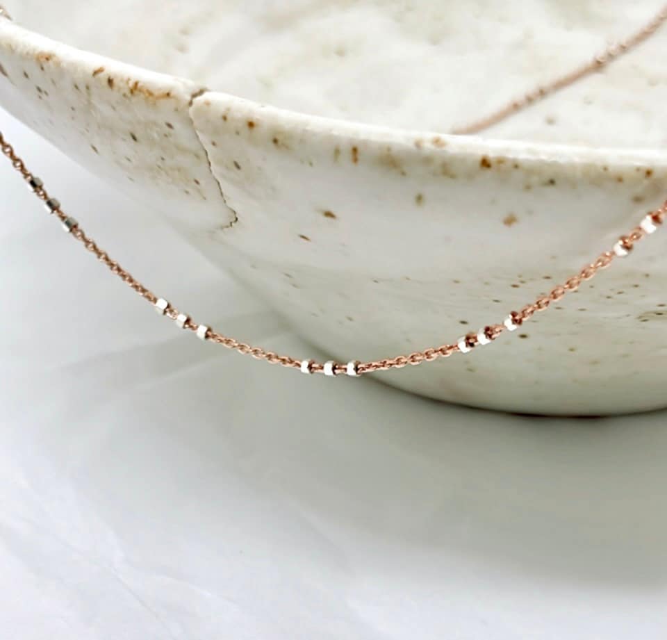 Two-tone Rose Gold and Sterling Silver satellite chain necklace featuring small silver beads spaced in sets of threes for a chic and contemporary look. Front View