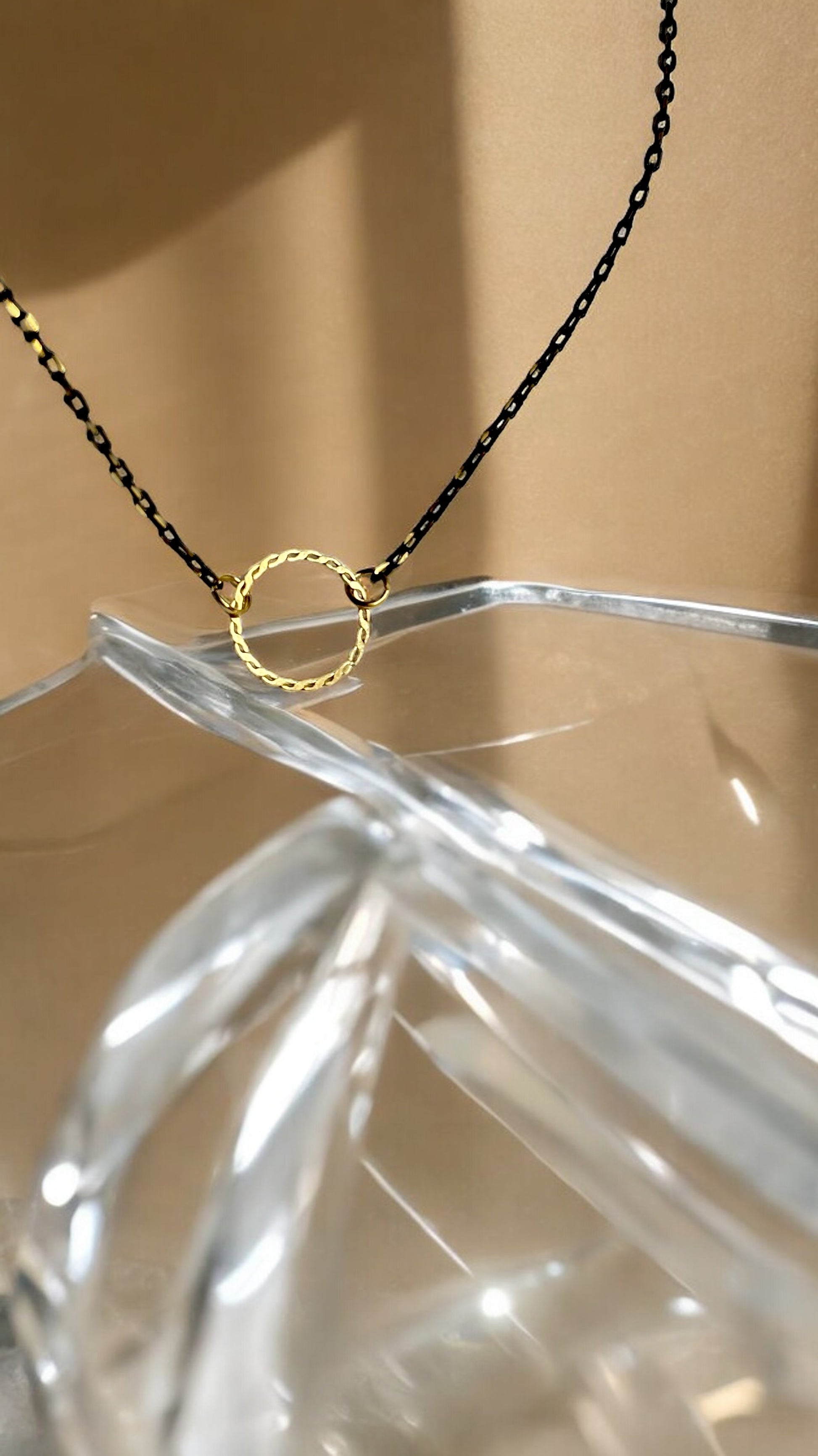 Dainty open circle choker necklace on black chain, on crystal glass