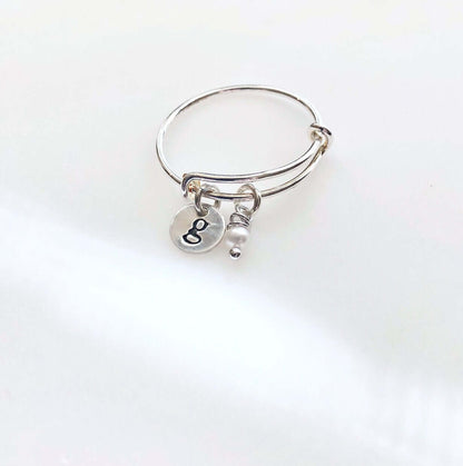 Adjustable Personalized Silver Charm Ring with stamped disc g and pearl on grey background