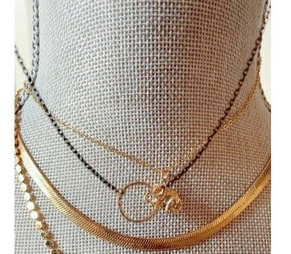 Dainty open circle choker necklace on black chain, perfect for layering with gold accessories as seen in this photo